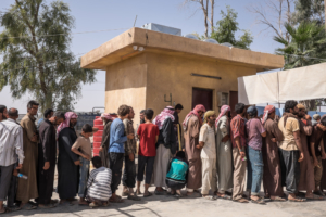 Fila para a documentação de saída do acampamento de deslocados de Ayn Issa.