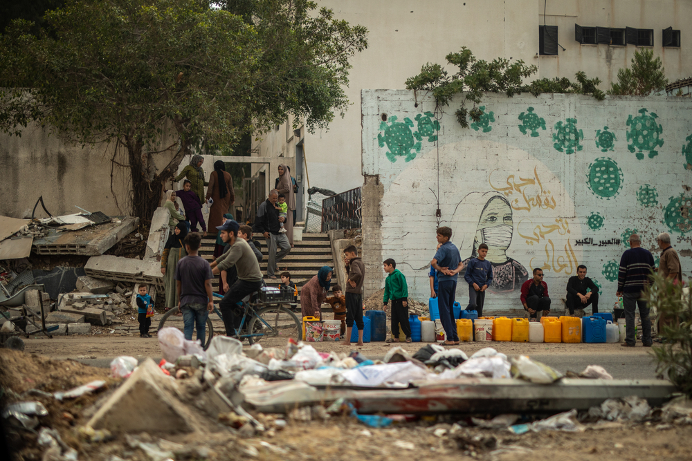 Na Al Jalaa Street, na Cidade de Gaza, as pessoas fazem fila para pegar água. © Motassem Abu Aser