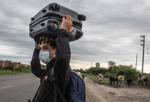 Um migrante venezuelano de 26 anos carrega seus pertences pela Rodovia Pan-Americana enquanto tenta chegar a Tumbes, no Peru. © Max Cabello Orcasitas