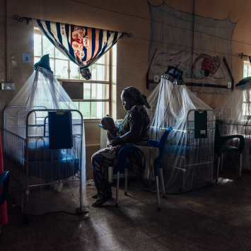 Amaka Joseph cuida de seu filho em recuperação no centro de nutrição terapêutica intensiva no Hospital Especializado de Sokoto, Nigéria. © KC NWAKALOR