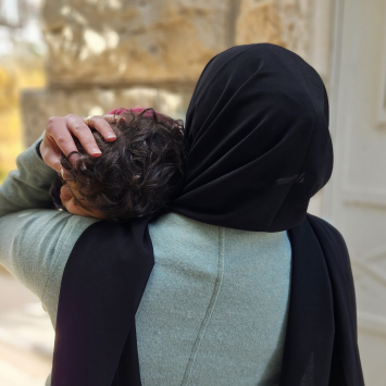 Aliyah*, mulher palestina que vive em Hebron, com a filha nos braços. Foto: Laora Vigourt/MSF