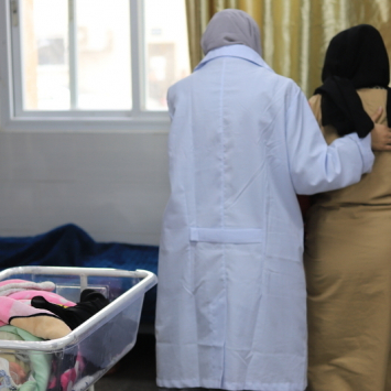 Profissional de saúde auxilia paciente no hospital Emirati, em Gaza. Janeiro de 2024. © Mariam Abu Dagga/MSF