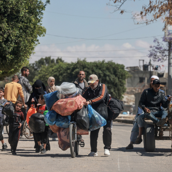 Um grupo de palestinos deslocados espera pela distribuição de água de MSF na área de Tal Al-Sultan, na cidade de Rafah, sul de Gaza. Janeiro de 2024. © MSF