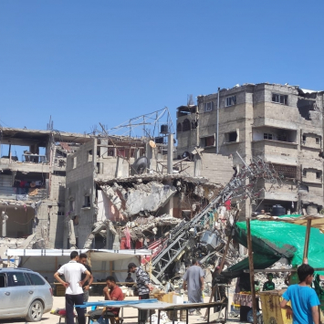 Pessoas em frente a um prédio bombardeado em Rafah. Faixa de Gaza, 10 de maio de 2024.