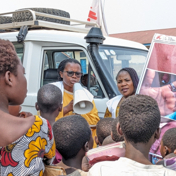 Equipe de promoção de saúde compartilhando informações sobre mpox em acampamento de pessoas deslocadas na RDC. ©Augustin Mudiayi/MSF