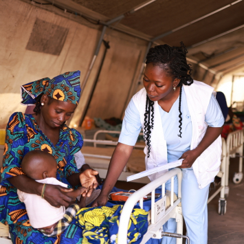 Profissional de MSF afere os sinais vitais de Nura, filha de Zainab, no centro de nutrição terapêutica intensiva Kofar Suari, no estado de Katsina. © Abba Adamu Musa/MSF