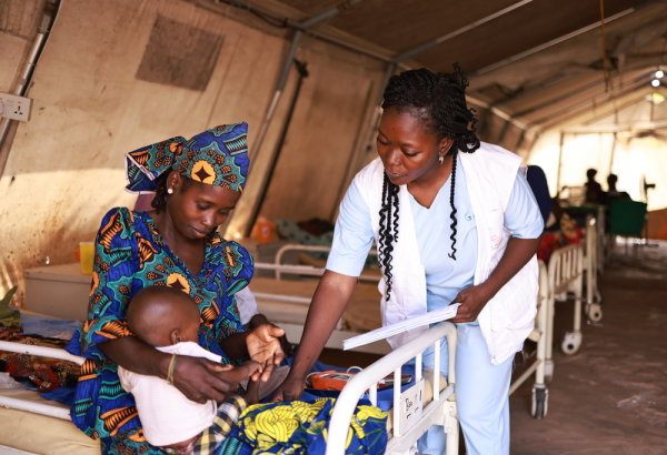 Profissional de MSF afere os sinais vitais de Nura, filha de Zainab, no centro de nutrição terapêutica intensiva Kofar Suari, no estado de Katsina. © Abba Adamu Musa/MSF