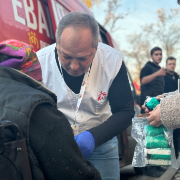 Oleksandr Hontariev, médico de MSF, realiza um tratamento inicial no braço de um paciente perto do centro de trânsito em Pavlohrad, região de Dnipropetrovsk. Ucrânia, novembro de 2024. © Yuliia Trofimova/MSF