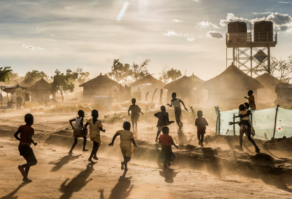 Foto: Frederic NOY/COSMOS
Legenda: Crianças do Sudão do Sul brincando no acampamento de refugiados de Bidibidi, em Uganda, em frente às instalações da MSF. Maio de 2017.